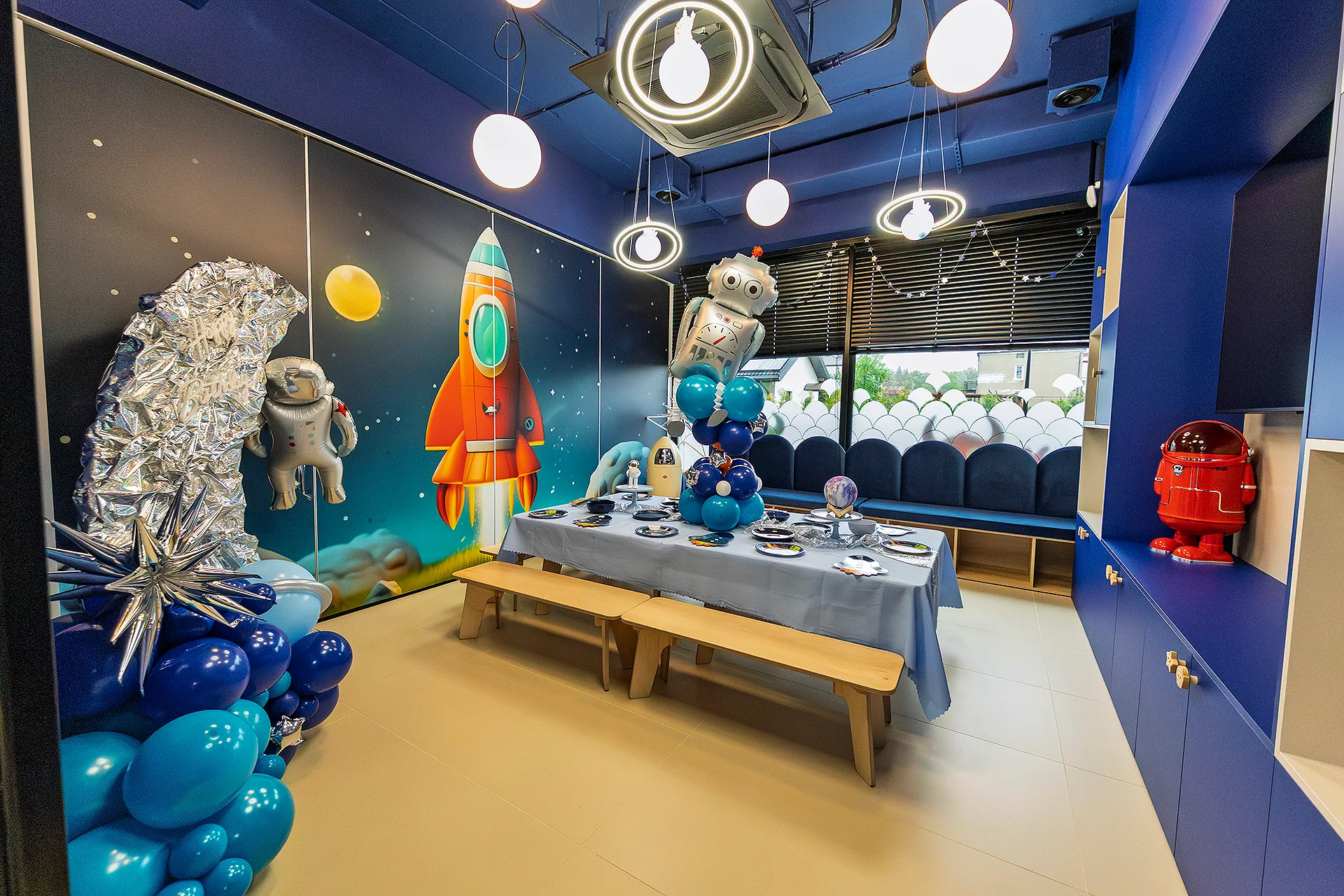 Sala kosmiczna — stół urodzinowy pod rakietą i balonami astronautów