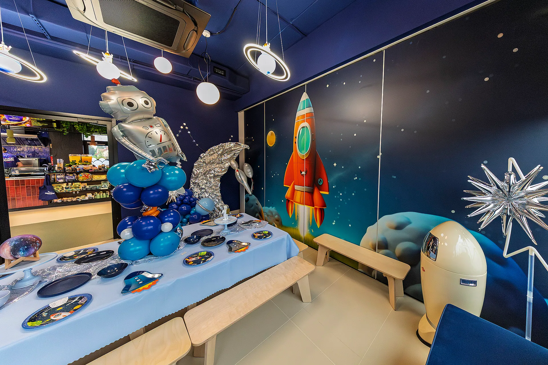 Sala kosmiczna — kosmiczne lampy i mural z rakietą