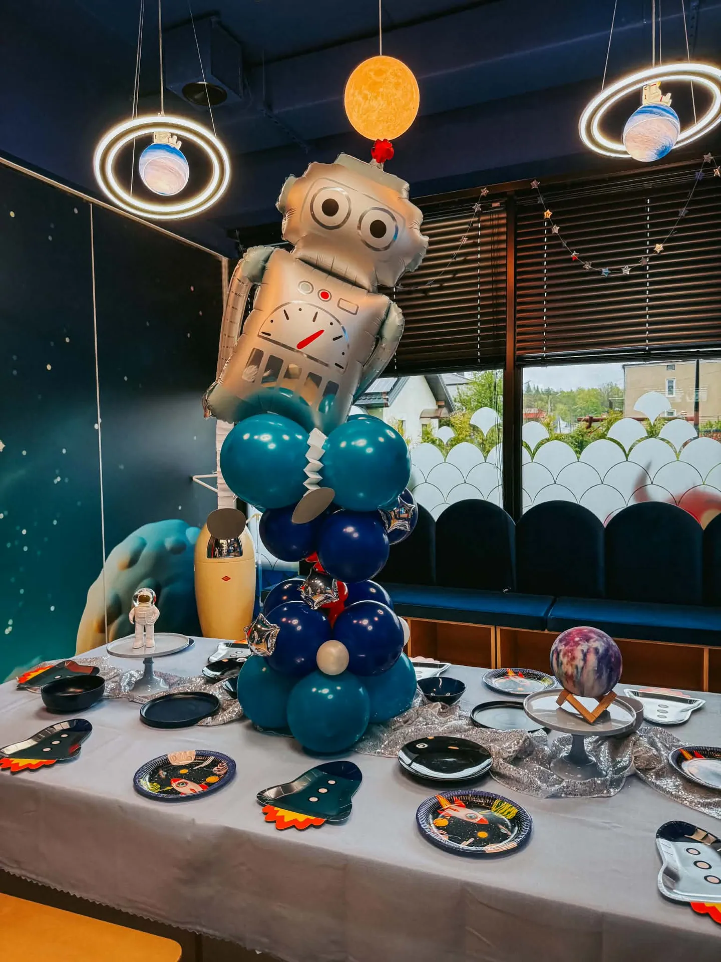 Sala kosmiczna — dekoracje planet i rakiet przy stole urodzinowym