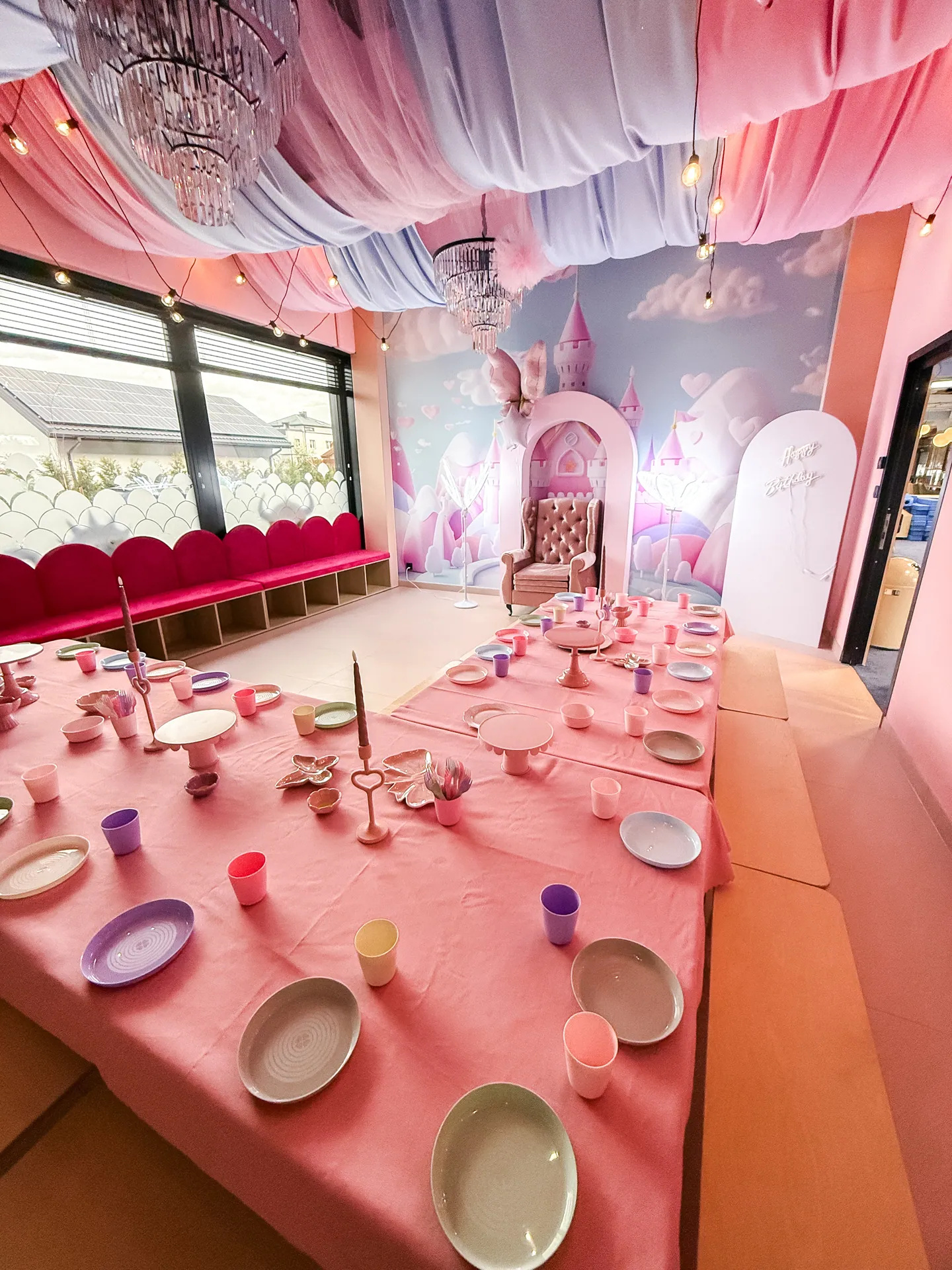 Sala księżniczki — różowe draperie, żyrandole i nakryty stół