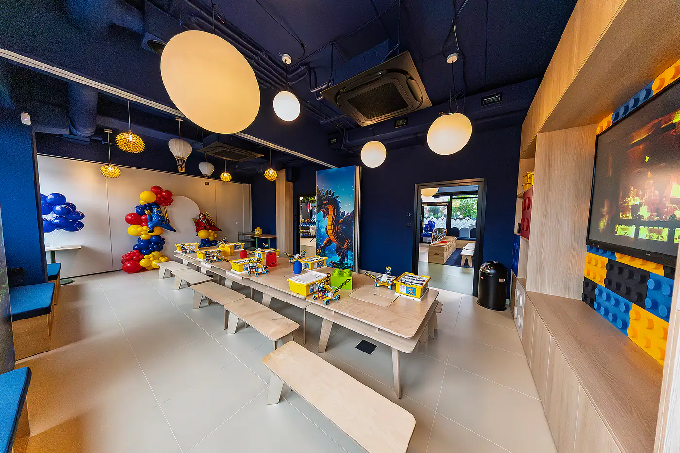 Sala klocków — ściana z klocków i balony przy stole